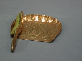 An Art Nouveau embossed copper crumb tray and brush