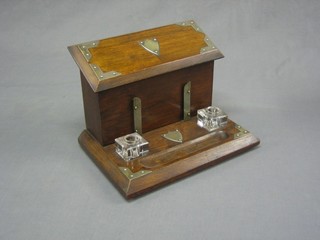 An Edwardian oak stationery box with hinged lid, base fitted 2 inkwells and a pen receptical 12"