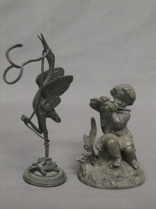 An Eastern bronze figure of a stork standing on a turtle 7" and a metal figure in the form of a seated cherub playing a flute 5"
