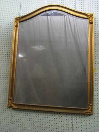 An arch shaped plate mirror contained in a decorative gilt frame 36"