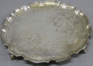 A circular silver salver with bracketed border, raised on 3 scrolled feet Chester 1934 54 ozs