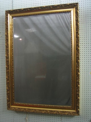 A  rectangular bevelled plate wall mirror contained in a decorative gilt frame 42