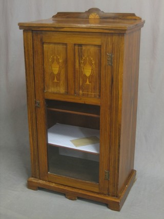 A Victorian rosewood music cabinet inlaid satinwood stringing and with raised back, the interior fitted shelves enclosed by a glazed panelled door and raised on bracket feet 21"