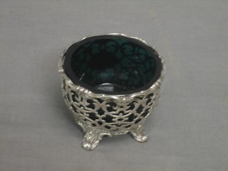 A circular Victorian pierced silver salt with green glass liner, raised on 4 shell carved supports, London 1851, 2 ozs