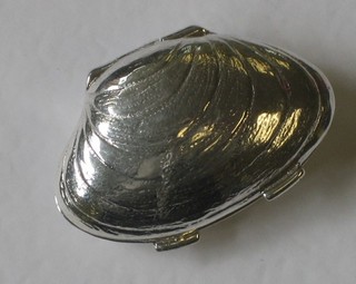 A silver trinket box in the form of a clam