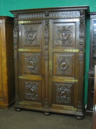 A large and impressive 19th Century Continental heavily carved oak armoire enclosed by panelled doors 62"