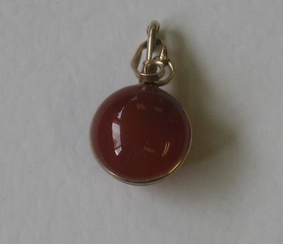 An amber coloured pendant with gold mounts