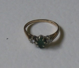 A yellow gold dress ring set an emerald supported by 2 diamonds