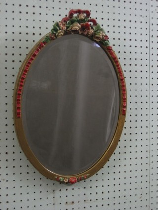 A 1930's oval bevelled plate wall mirror contained in a barbola mounted frame 19"