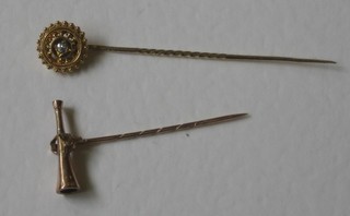 A gold stick pin set a diamond and 1 other in the form of a hunting horn with foxes mask