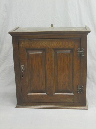 An 18th/19th Century oak hanging "spice" cabinet enclosed by a panelled door 24"