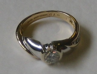 An 18ct two colour gold dress ring set a solitaire diamond and diamonds to the shoulders, approx 0.57ct