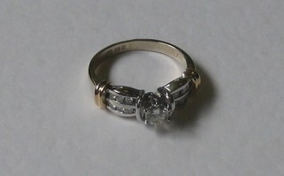 A lady's 18ct yellow gold dress ring set a diamond and with numerous diamonds to the shoulders, approx 0.40ct