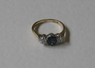 An 18ct yellow gold and platinum dress ring set a sapphire supported by 2 diamonds