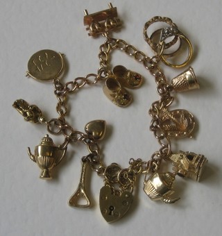 A gold curb link charm bracelet hung numerous charms