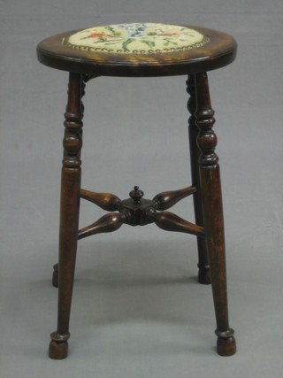 A Victorian circular mahogany stool with Berlin wool work seat, raised on turned supports with X framed stretcher 12"