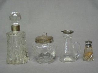 A circular glass preserve jar with silver lid, a glass salts jar with silver lid, a glass whisky tot and a cut glass scent bottle with silver band