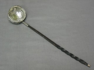 An embossed silver toddy ladle, set a gilt Queen Anne 1707 shilling with whale bone handle