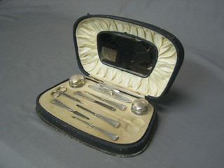 An Art Deco 8 piece silver backed manicure set with button hook, nail buffer, 2 cylindrical glass jars with silver lids etc Birmingham 1930, cased (missing pair of scissors)