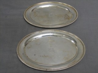 A pair of oval silver plated sauce boat stands with armorial decoration and gadrooned borders 7 1/2"