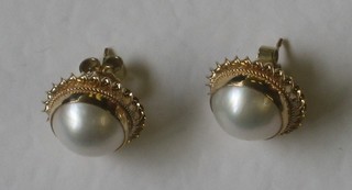 A pair of 9ct yellow gold ear studs set pearls
