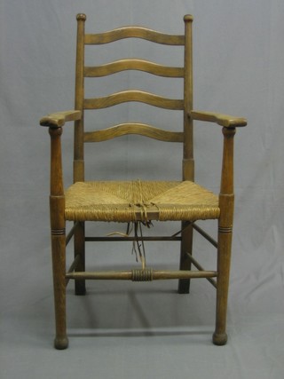 A beech ladder back carver chair with woven rush seat, raised on turned supports