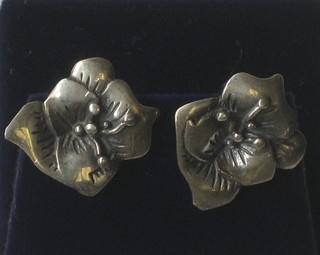 A pair of silver ear studs in the form of roses