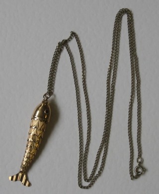 A gilt metal articulated fish pendant hung on a gilt chain
