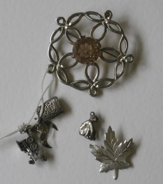 A silver brooch in the form of a Maple leaf, 1 other brooch and 3 charms