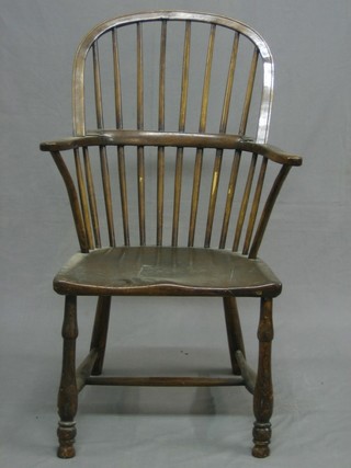 An 18th/19th Century elm stick and rail back kitchen carver chair with solid elm seat, raised on turned supports with H framed stretcher (cut down)