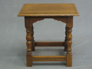 A rectangular honey oak stool raised on turned and block supports 18"