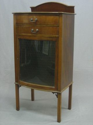 An Edwardian walnut bow front music cabinet with raised back, the base fitted 2 drawers above a cupboard, raised on square tapering supports 21"