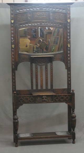 A Victorian carved oak hall stand, the centre with arched plate mirror, the base fitted a drawer, raised on bulbous turned and block supports, complete with drip trays 36"