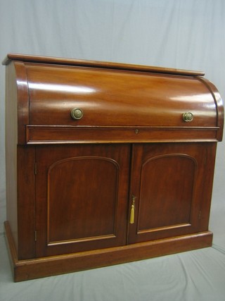 A Victorian mahogany cylinder bureau with well fitted interior, the base fitted a cupboard enclosed by an arched panelled door, raised on a platform base 48"