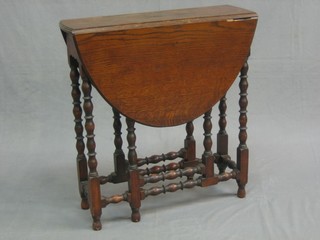 A Victorian oak oval drop flap gateleg tea table, raised on bobbin turned supports 24"