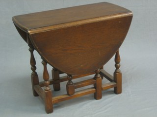 An oak oval dropflap gateleg tea table, raised on turned supports 23"