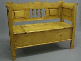 A Continental stripped and polished pine settle, the base with hinged seat 48"