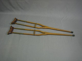 A pair of 1920's brass and mahogany sprung crutches