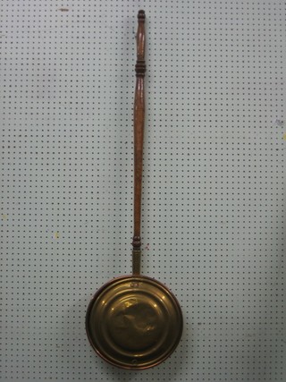 An 18th Century brass and copper warming pan with turned fruit wood handle
