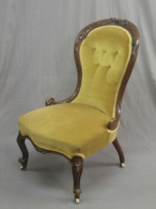 A Victorian carved walnut show frame nursing chair upholstered in yellow material and raised on cabriole supports