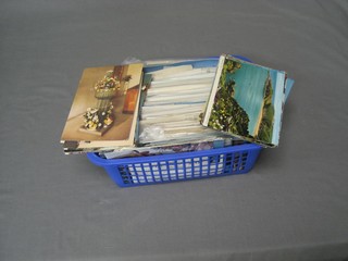 A blue plastic crate of various postcards