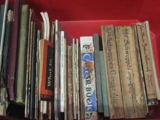 A red plastic crate containing a collection of various 1930's holiday guides and other ephemera etc