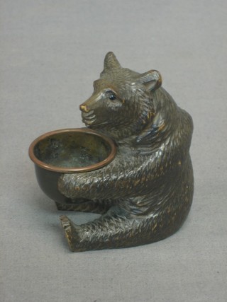 A Swiss carved figure of a seated bear holding a metal ashtray 3"