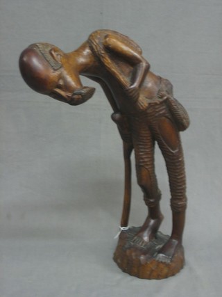 An African carved figure of a walking man 21"