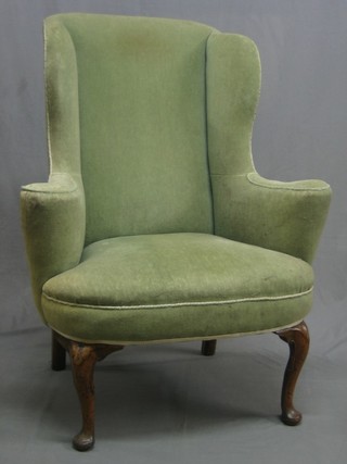 A handsome Queen Anne style walnut framed wing armchair, upholstered in green Dralon