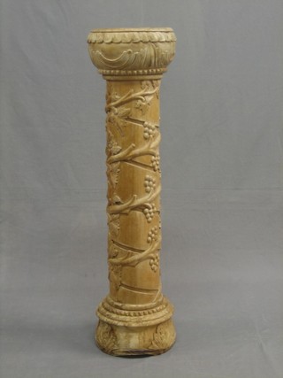 A turned and carved hardwood torchere with vinery decoration 38"