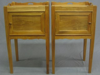 A pair of Georgian style bleached mahogany tray top bedside cabinets enclosed by panelled doors, raised on square tapering supports 18" 