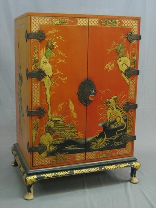 A 1930's lacquered chinoiserie style cocktail cabinet with hinged lid, the front enclosed by panelled doors, raised on cabriole supports 26"