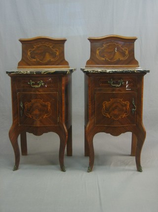 A pair of French inlaid Kingwood bedside cabinets of serpentine outline, with raised backs and black veined marble tops, each fitted a drawer above a double cupboard, raised on cabriole supports 21"