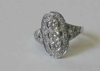 A lady's 18ct white gold dress ring set 3 diamonds and supported by numerous diamonds